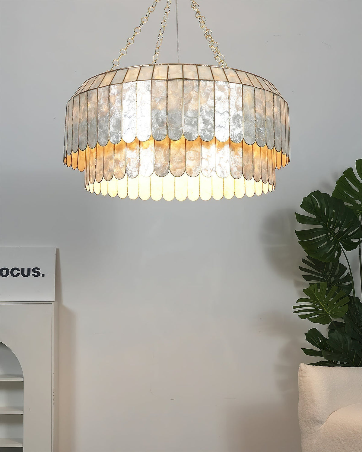 View of the lamp's gold ceiling mount and hanging chain.