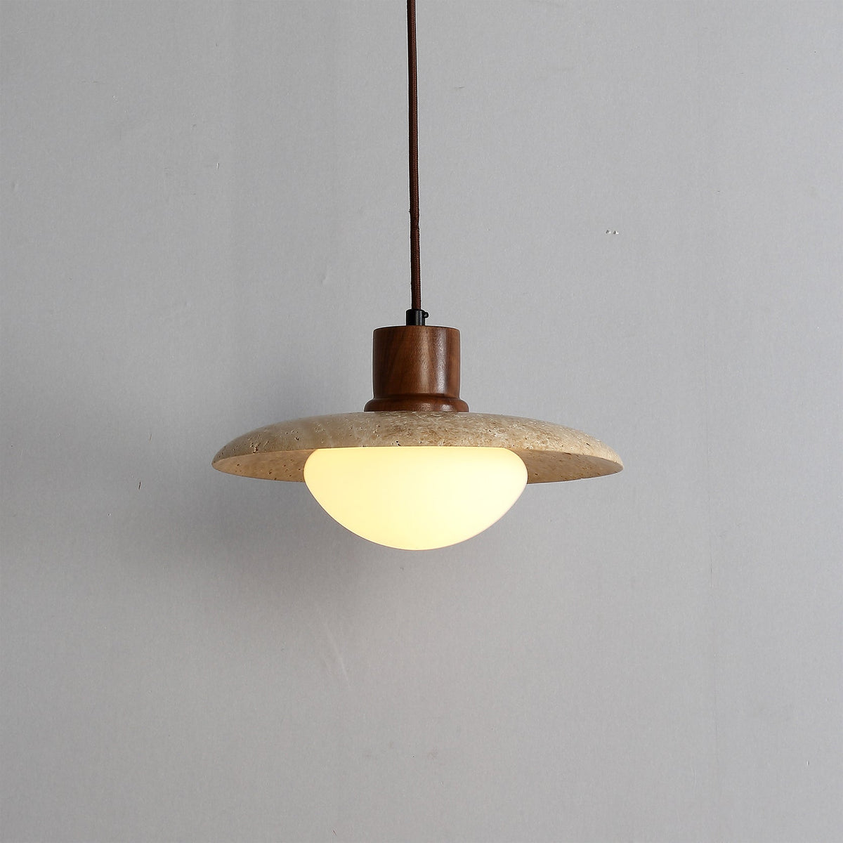 A detailed view of the yellow travertine material of the pendant lamp.
