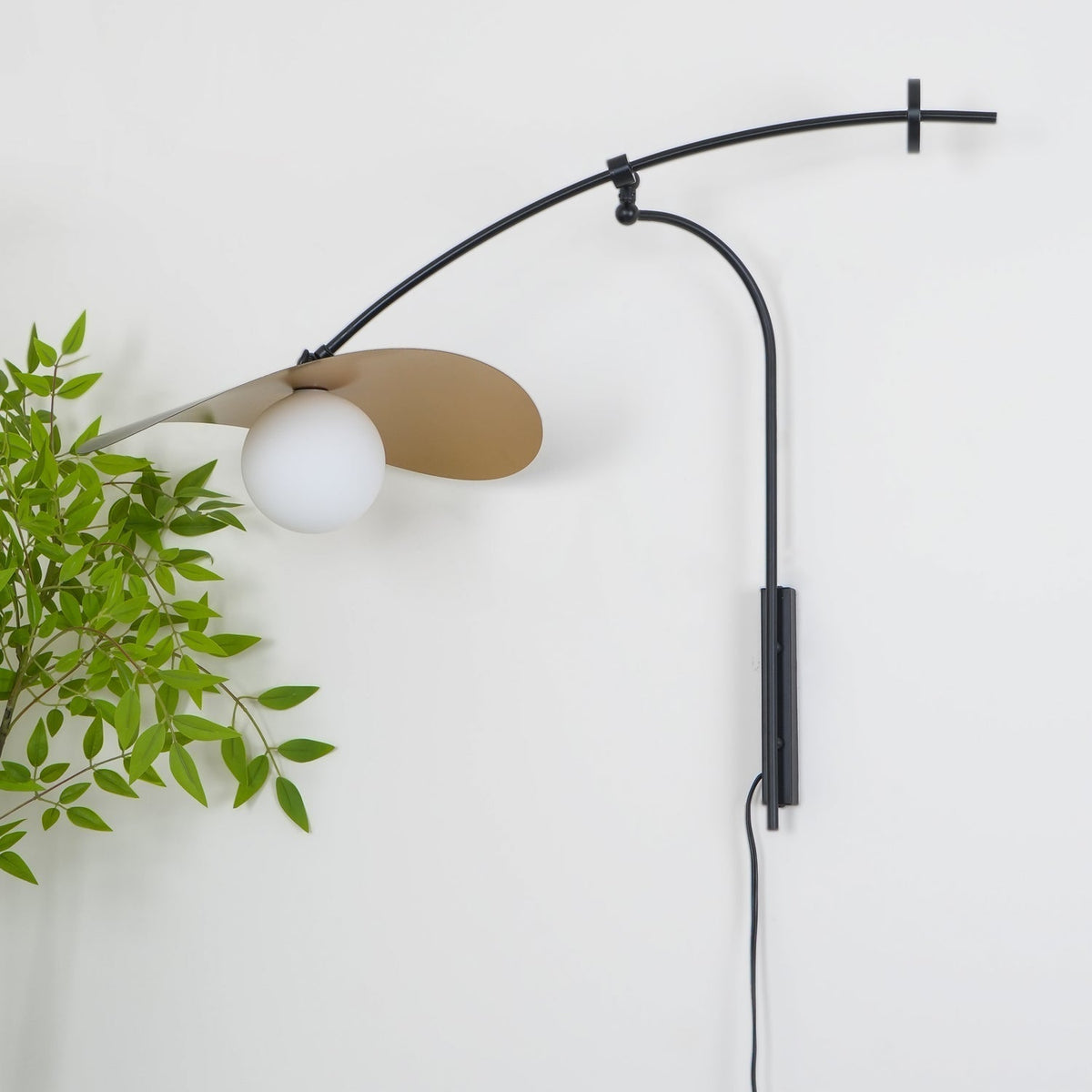 The small size Myrna Wall Lamp in a minimalist bedroom setting.