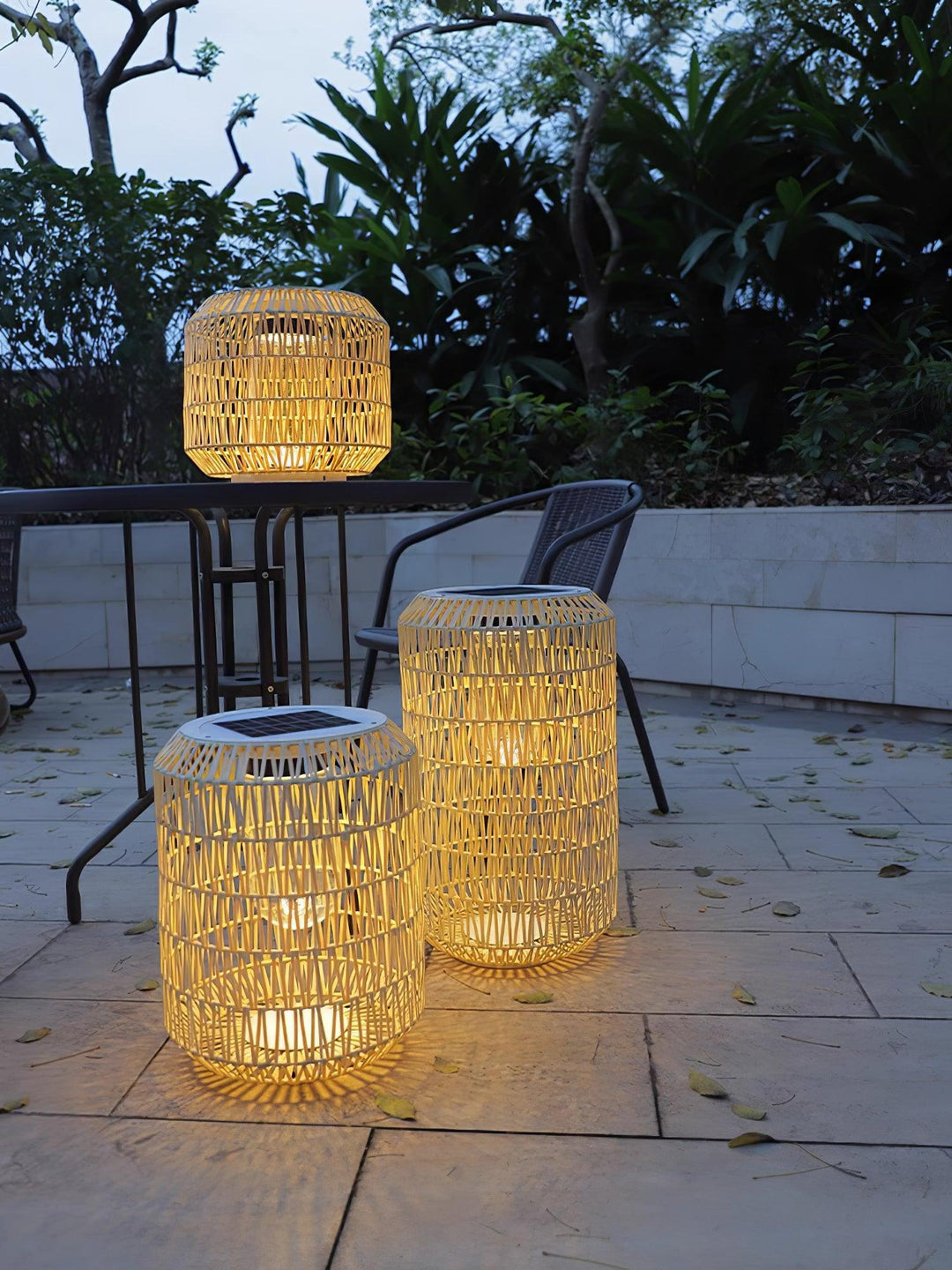 The outdoor lamp shown illuminating a patio setting at dusk.
